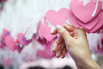 Close-up of hand holding pink heart shape