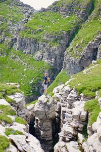 Man standing on cliff against mountain