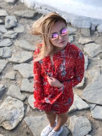 Young woman wearing sunglasses standing on rock