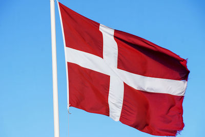 Low angle view of flag against blue sky