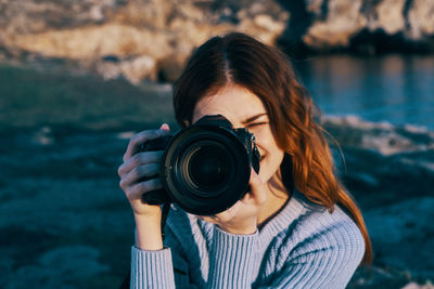 Portrait of woman photographing with camera