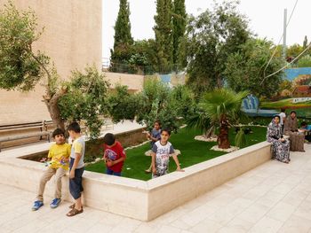 People sitting on plant against building