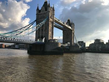 View of bridge over river against cloudy sky