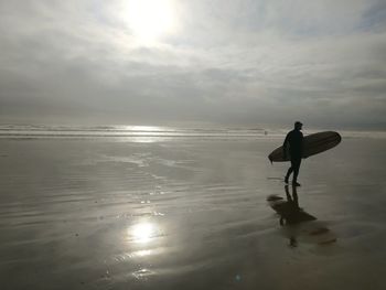 Man standing on beach against sky