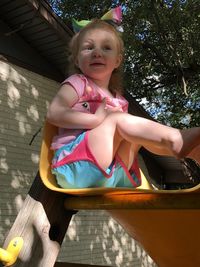 Full length of cute girl sitting on slide