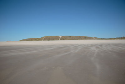 Scenic view of desert against clear blue sky