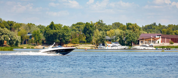 The motor boat moves quickly along the water surface of the river.