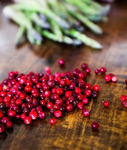 Red berries and asparagus on wooden table