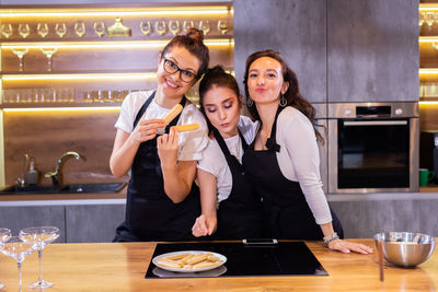 Portrait of smiling female friends working in cafe