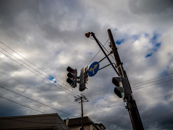 Low angle view of electricity pylon and traffic lights  against sky