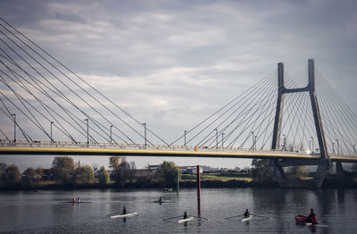 View of suspension bridge over river against sky