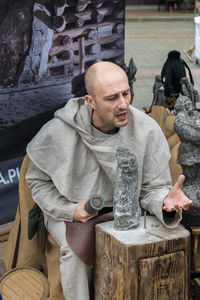 Full length of man sitting in traditional clothing standing in winter