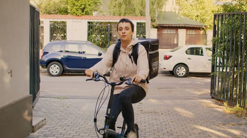 Rear view of man riding bicycle on street