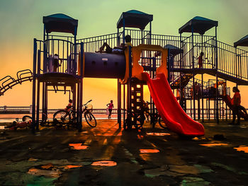 Children playing on jungle gym against sky