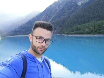 Portrait of young man with reflection in lake