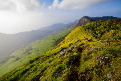 Scenic view of green mountains against sky