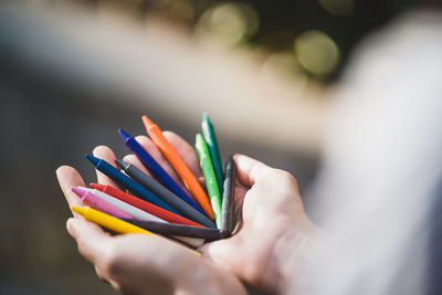 Close-up of hand holding crayons