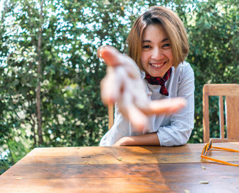 Portrait of a smiling young woman sitting on table