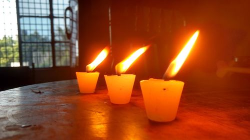 Close-up of illuminated candles on table