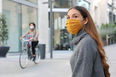 Portrait of woman with bicycle in city