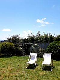 Chair on field against sky