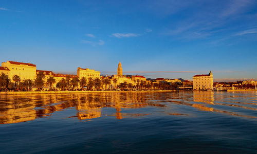 Reflection of buildings in city at waterfront