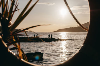 Silhouette boats in sea against sunset sky