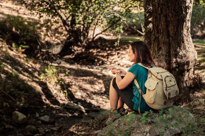 Woman with daughter sitting in forest