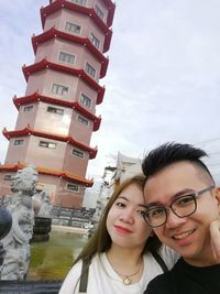 Portrait of smiling young woman against blue sky