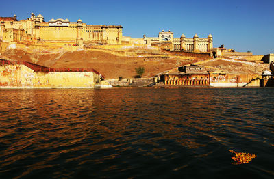 View of maota lake by amber fort against clear blue sky