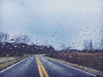 Road seen through wet glass window