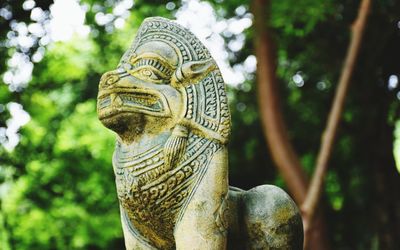 Low angle view of statue against trees