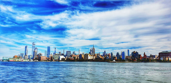 View of buildings in city against cloudy sky