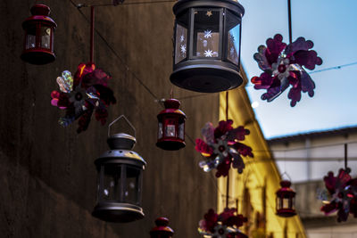 Low angle view of illuminated electric lamp against plants