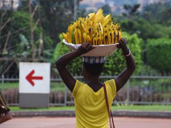Rear view of female vendor selling bananas on street