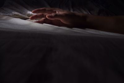 Close-up of hands on bed at home