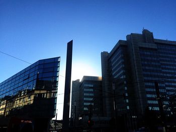 Low angle view of skyscrapers against clear blue sky