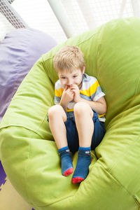 Portrait of boy sitting on bed