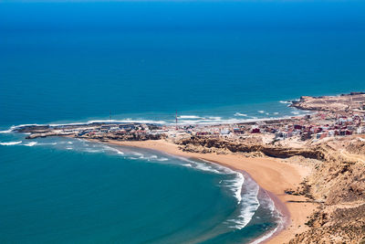 High angle view of sea shore against blue sky