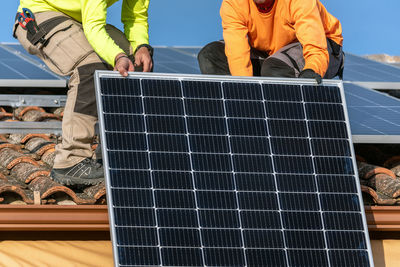 Low angle view of man standing on solar panel