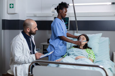 Nurse giving oxygen to patient in clinic