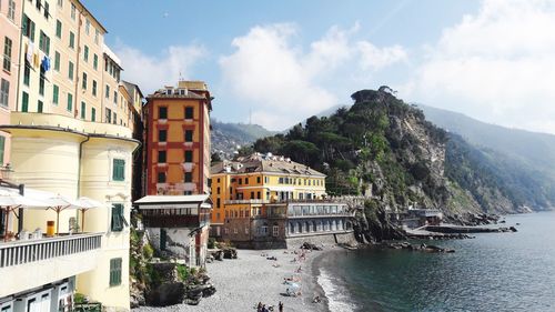 Buildings by sea against sky in city