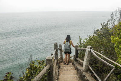 Rear view of woman looking at sea against sky
