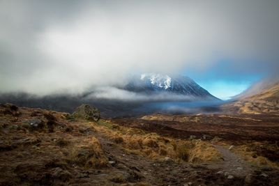 Scenic view of mountains against cloudy sky