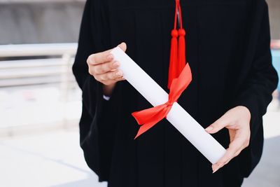 Midsection of woman holding degree