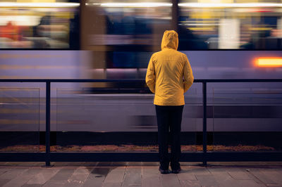 Rear view of man standing at railroad station