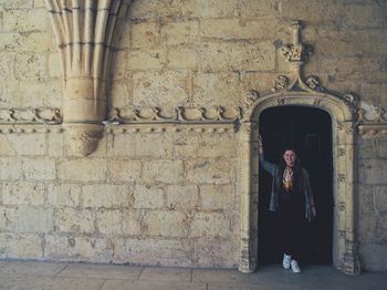 Full length of woman standing against building