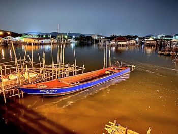 Boats moored in harbor at lake against sky