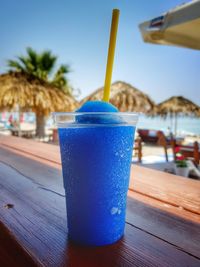 Close-up of drink on table against blue sky