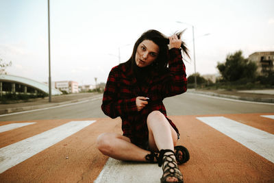 Full length of woman sitting on road